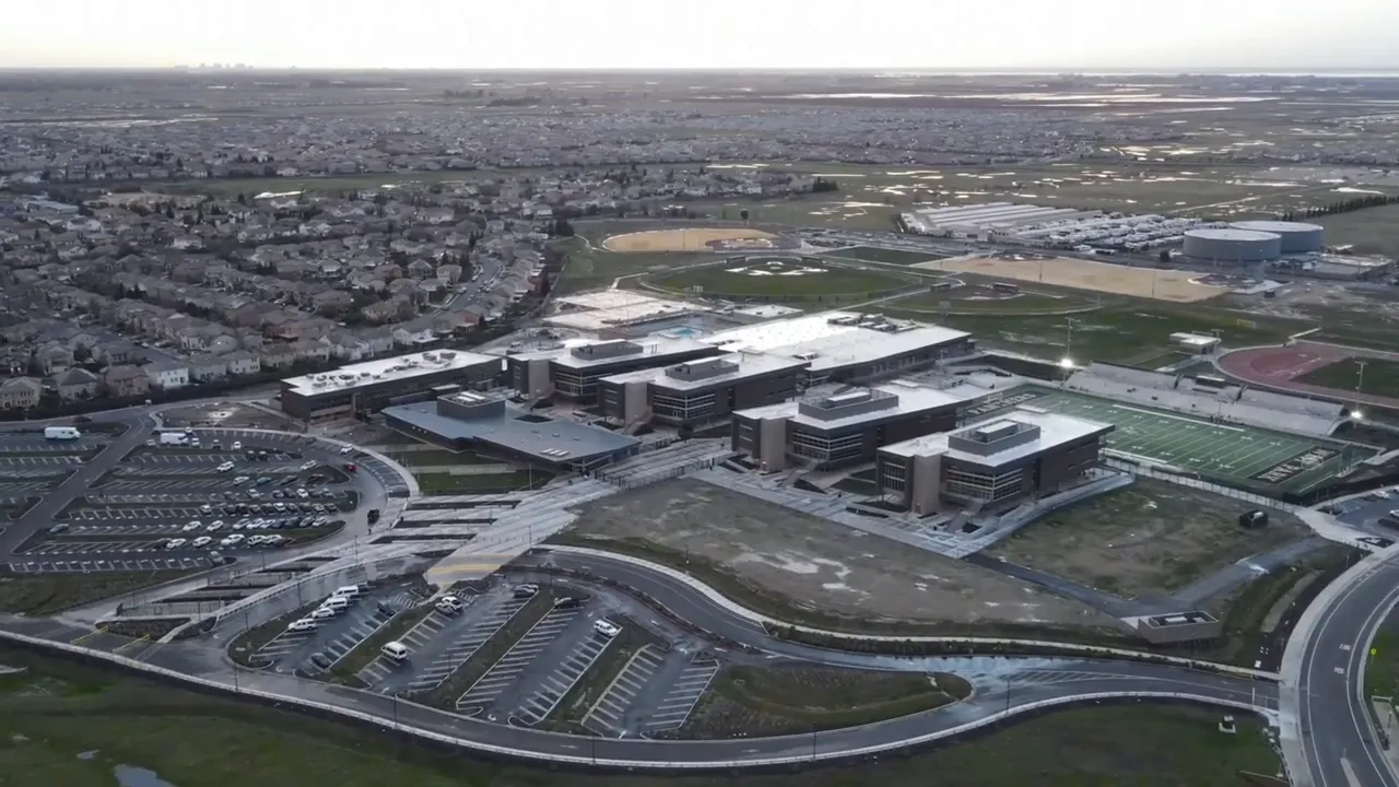 Parents walking students toward modern school campus