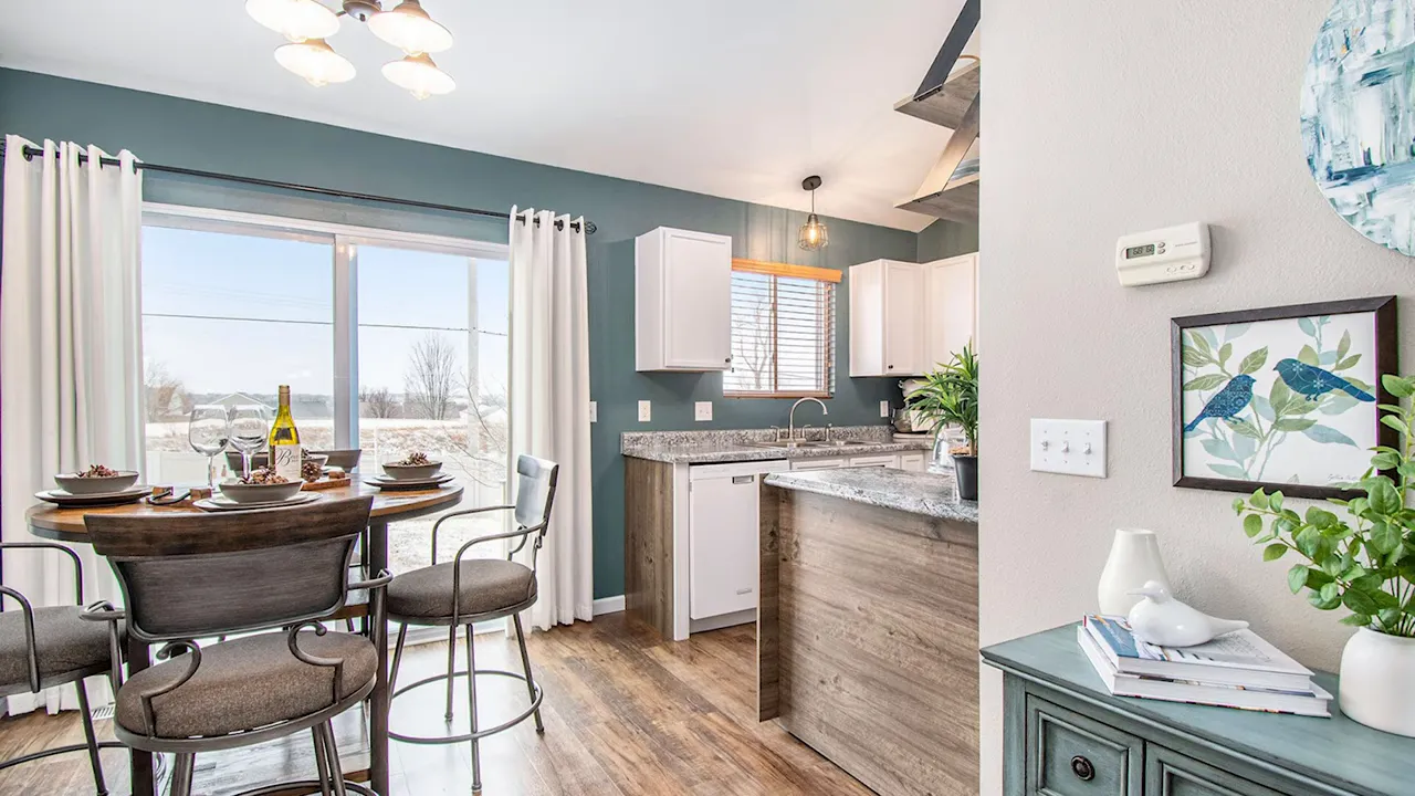 Staged kitchen and dining area with table set, sliding glass door and modern finishes.