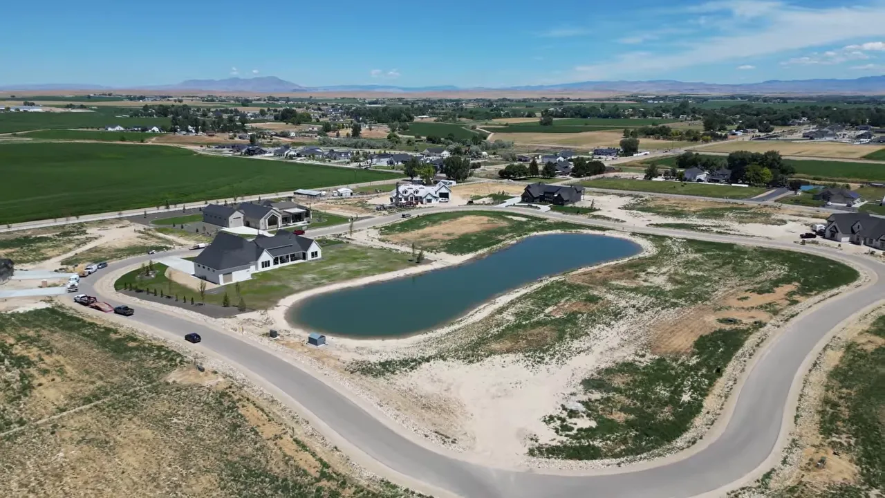 Aerial view of acreage homes and ponds surrounded by farmland