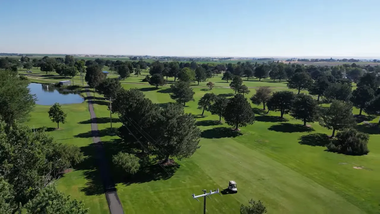 Aerial view of green fairways and trees at Purple Sage Golf Course