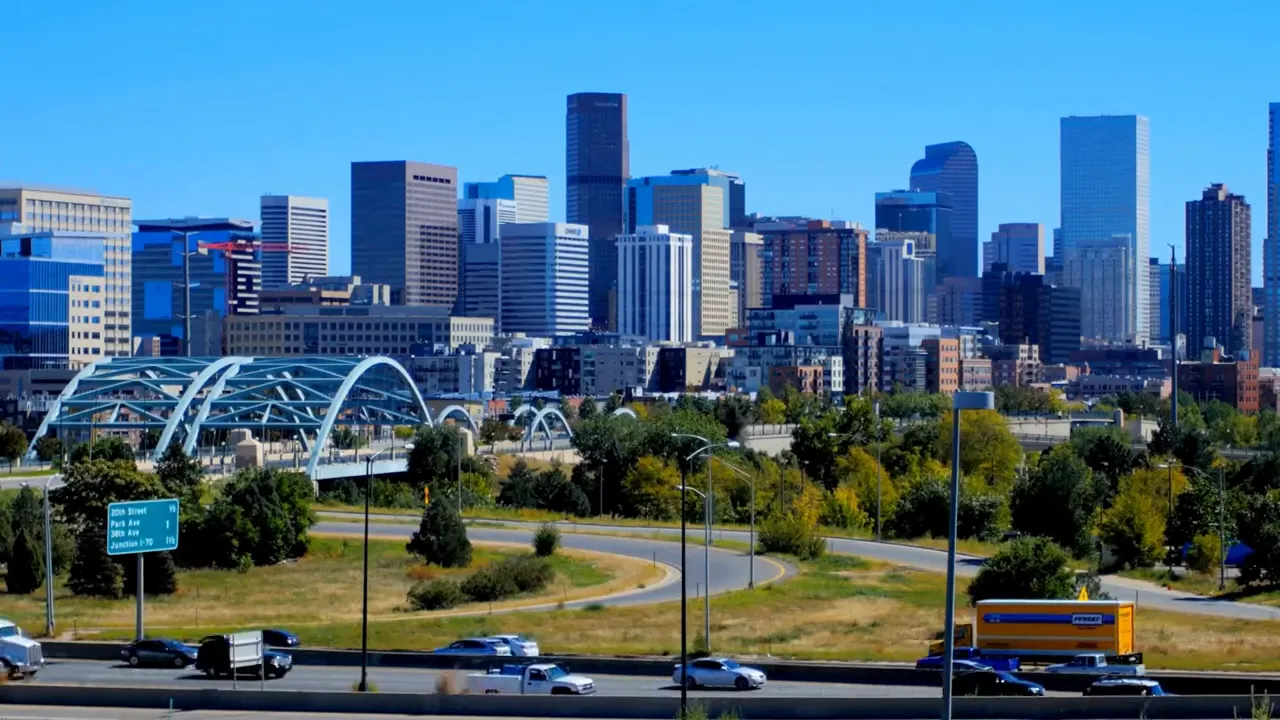 Panoramic view of downtown Denver skyline with highway and bridge