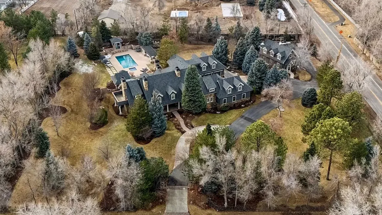 Aerial view of a sprawling luxury home estate with pool, landscaping, and large lot