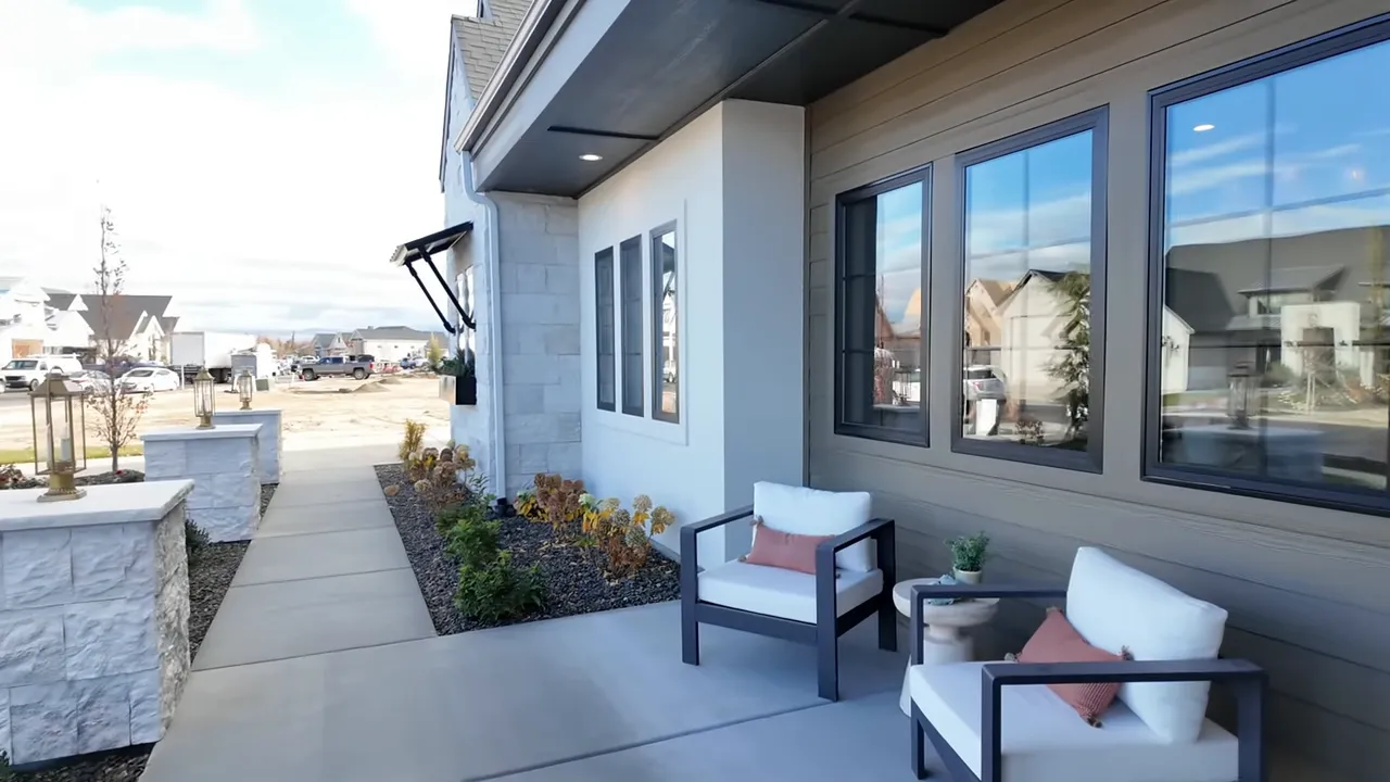 Front porch with seating, large windows, stone-clad low walls and walkway showing exterior curb appeal