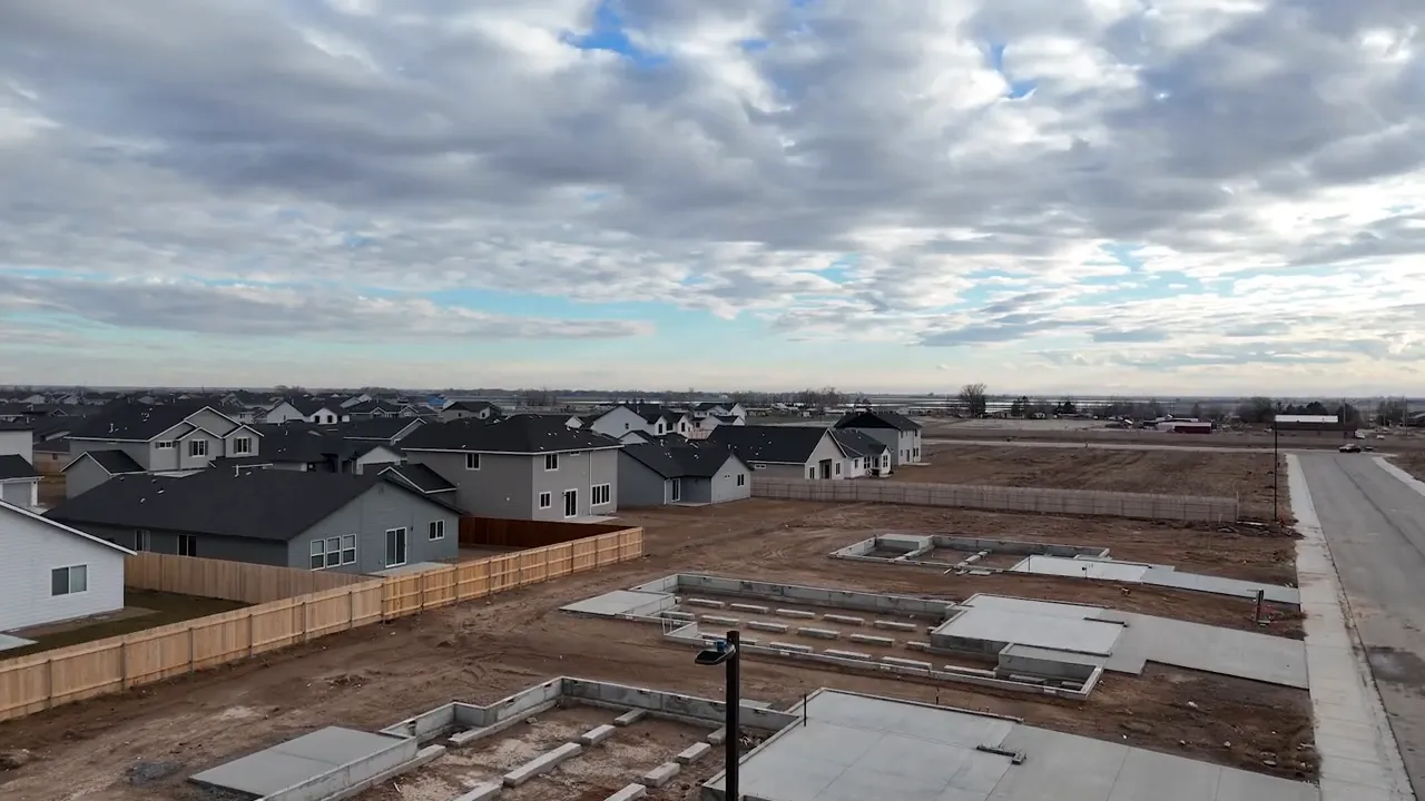 new subdivision lots with concrete foundations and houses under construction