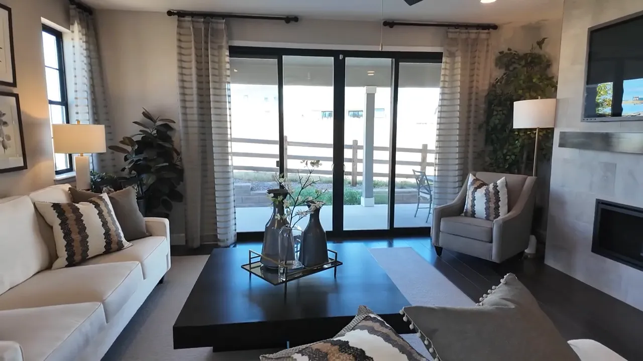 Wide view of the living room with sliding glass doors and covered deck access in the Richmond Arlington model at Independence subdivision, Elizabeth Colorado