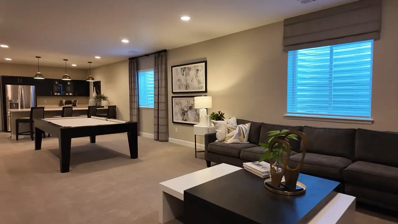 Finished basement living area with sectional sofa and large windows in the Arlington model in Independence subdivision near Elizabeth, Colorado