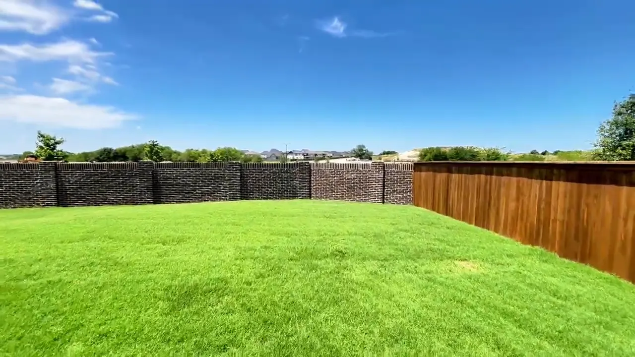 Large green fenced backyard under a blue sky