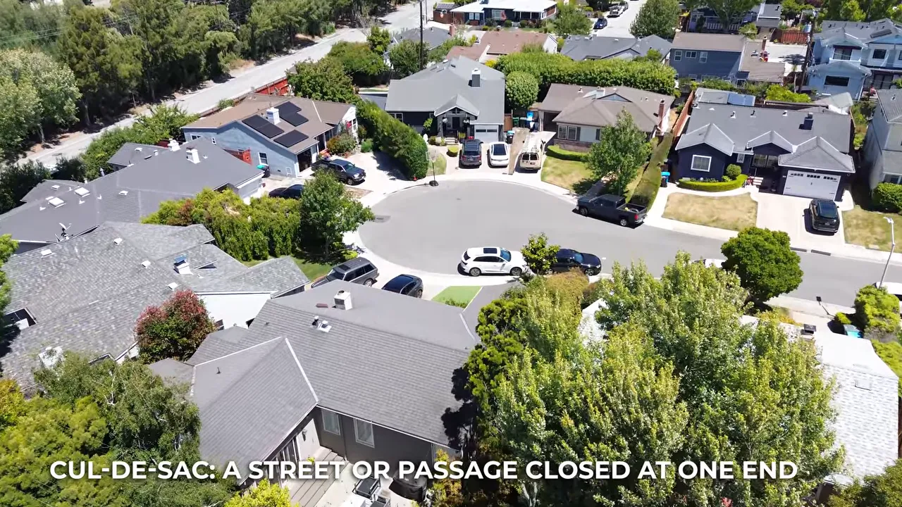 Aerial view of a circular cul de sac surrounded by single family homes and parked cars