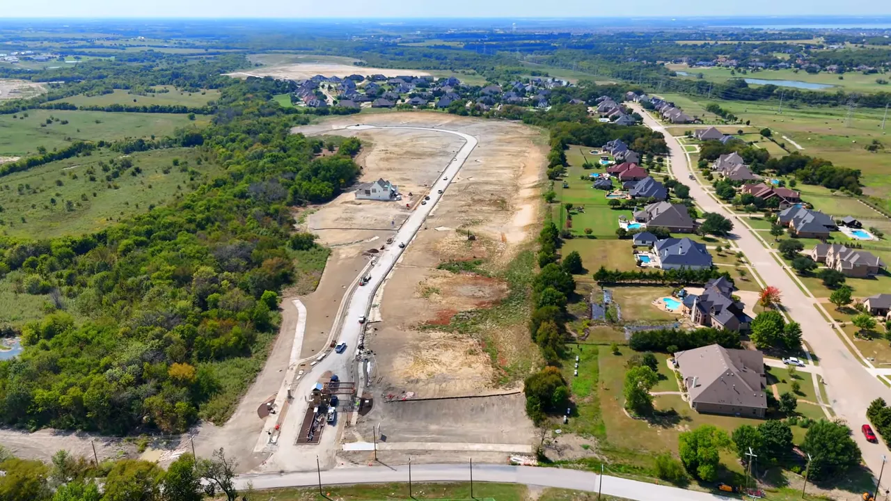 aerial view of Estates at Bristol Valley showing cleared acre-sized lots, roads, and adjacent homes in Heath Texas