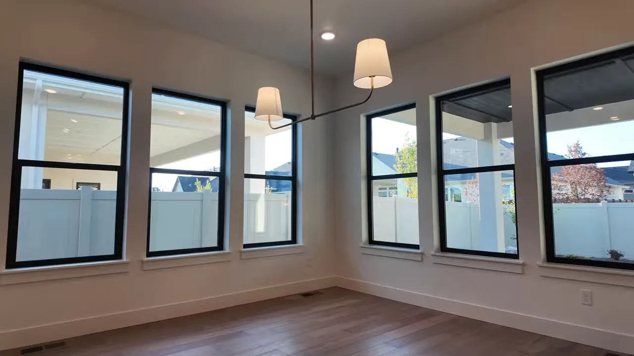 Dining room with multiple black-framed windows and pendant light fixture