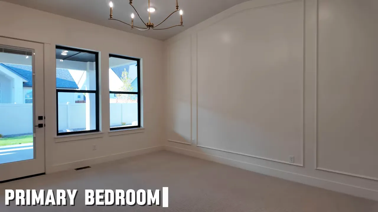 Primary bedroom with wall paneling chandelier and patio door