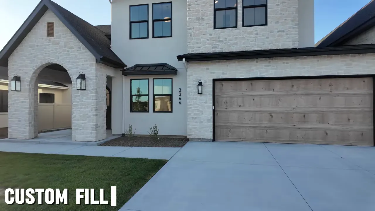 White stone home exterior with wood garage door and arched entry