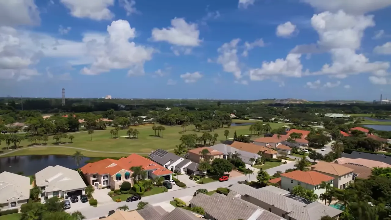 Aerial view of a golf community neighborhood with large homes and green landscaping in West Palm Beach