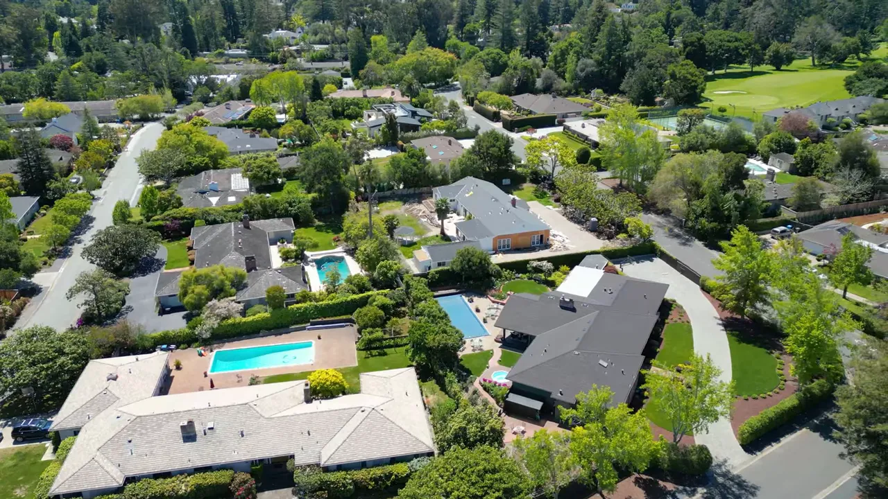 Drone shot of homes with rectangular pools and spacious yards in Skyfarm neighborhood.