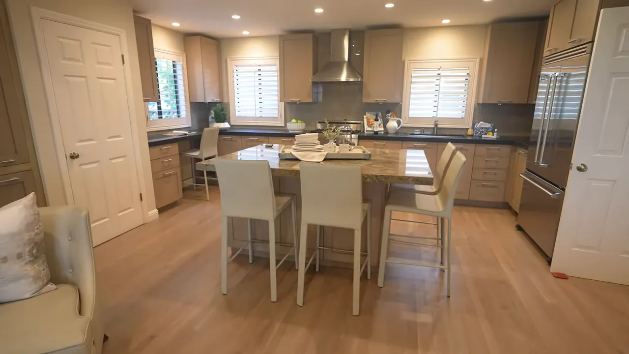 bright open kitchen with center island and four bar stools, custom cabinetry and stainless hood