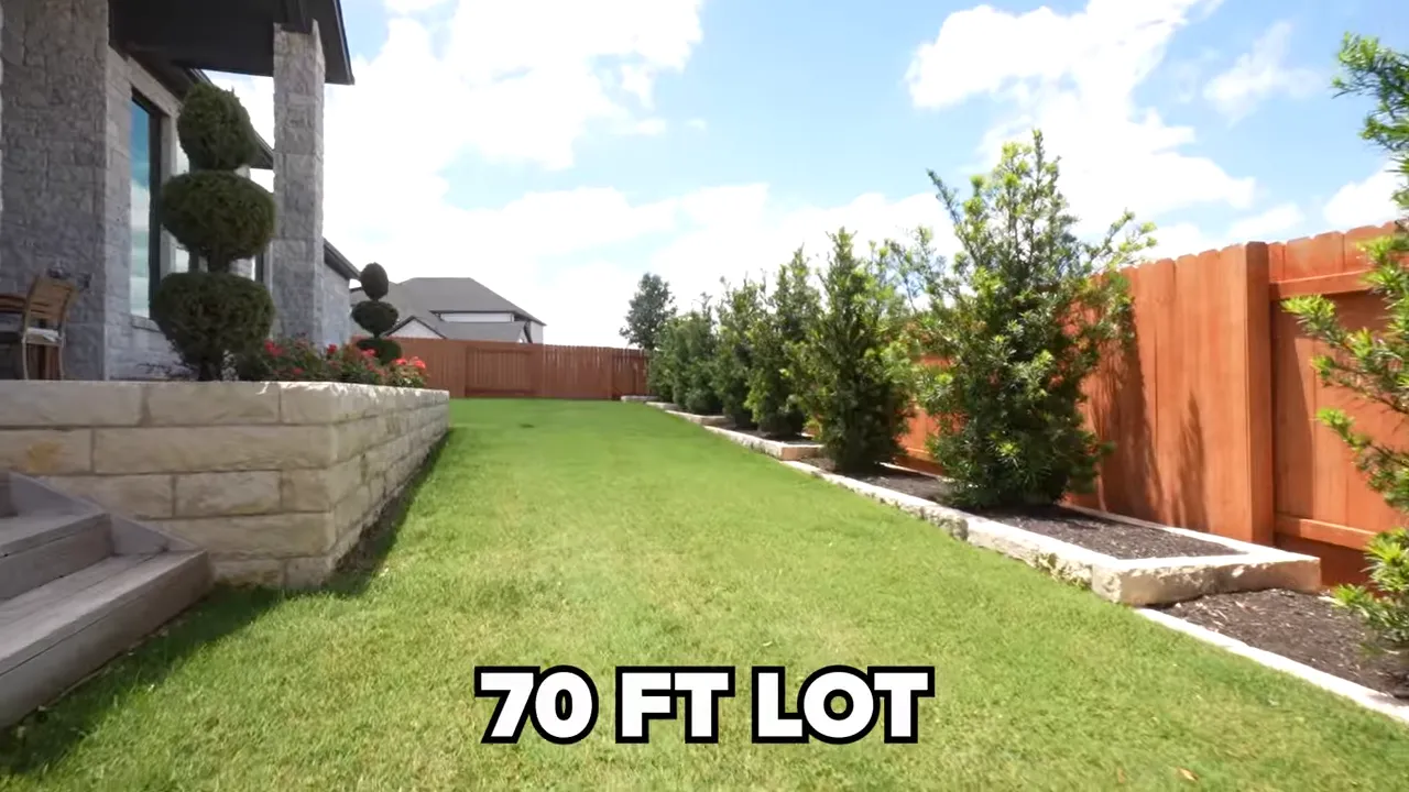 Side yard lawn with landscaping and text reading 70 FT LOT