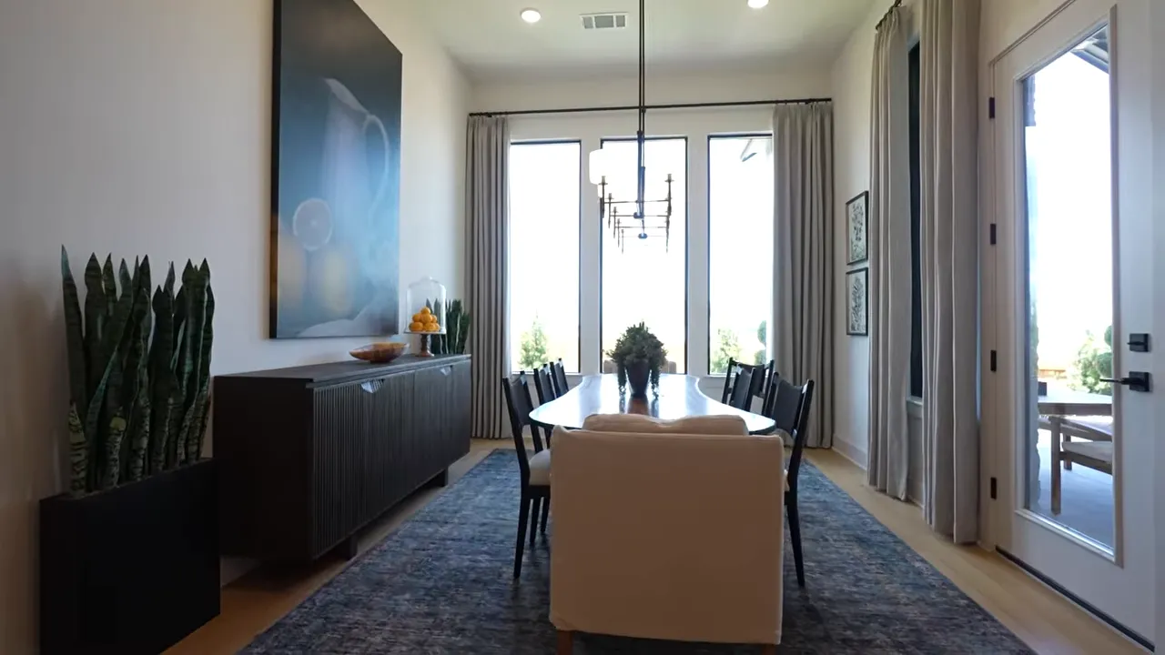 Dining room with long table pendant lighting and glass doors to patio