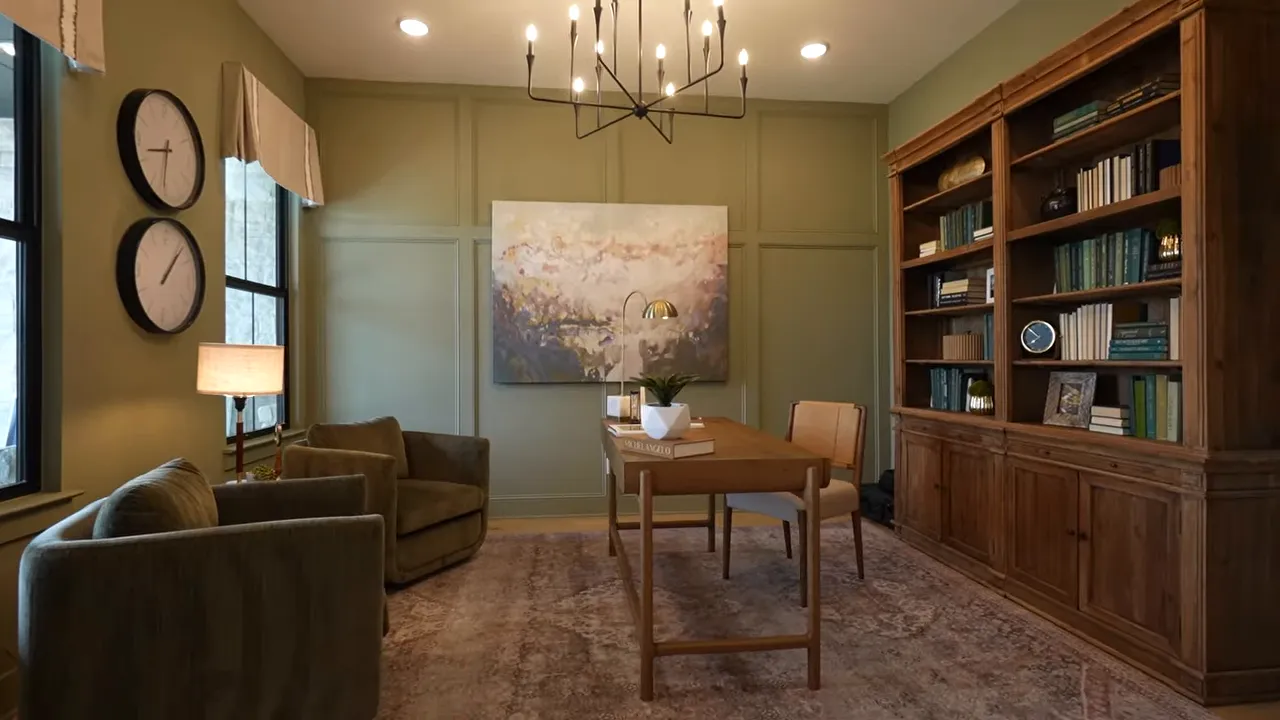 Study with chandelier desk chairs built in bookshelves and green walls
