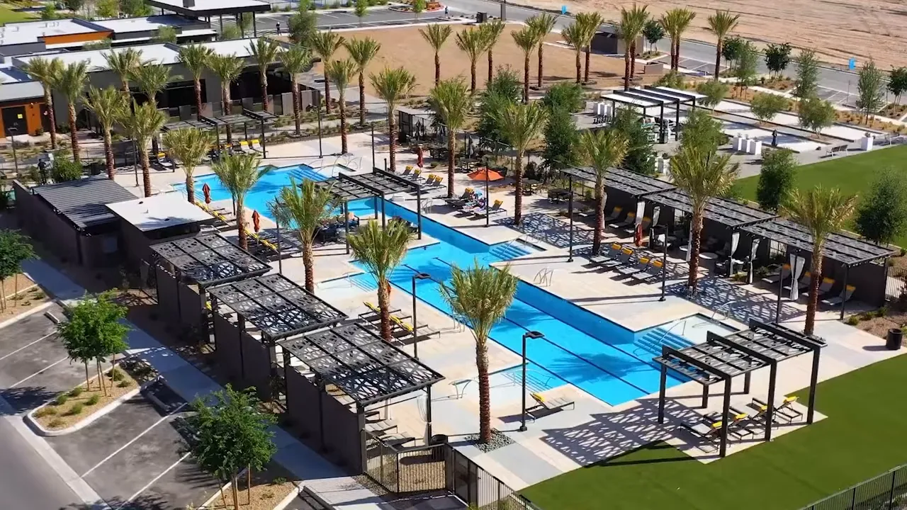 Aerial view of Trilogy resort pool with palm trees lounge areas and cabanas