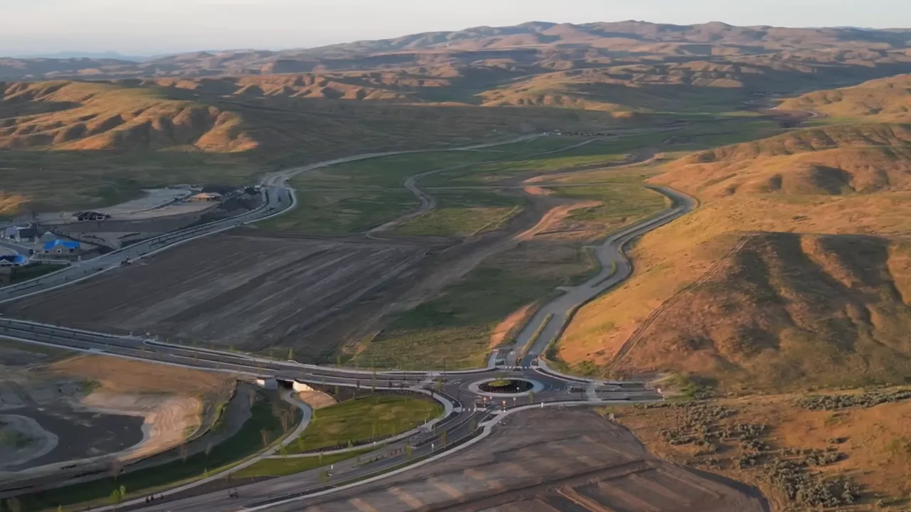 Aerial photograph showing a roundabout, roads, trail corridors, and rolling foothills across the Valnova development.