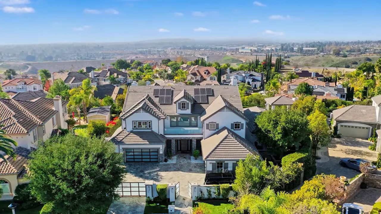 Large hillside home with neighborhood view in the background
