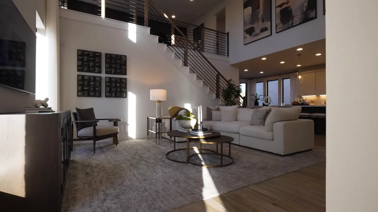 spacious living room with sectional sofa coffee tables staircase and high ceilings