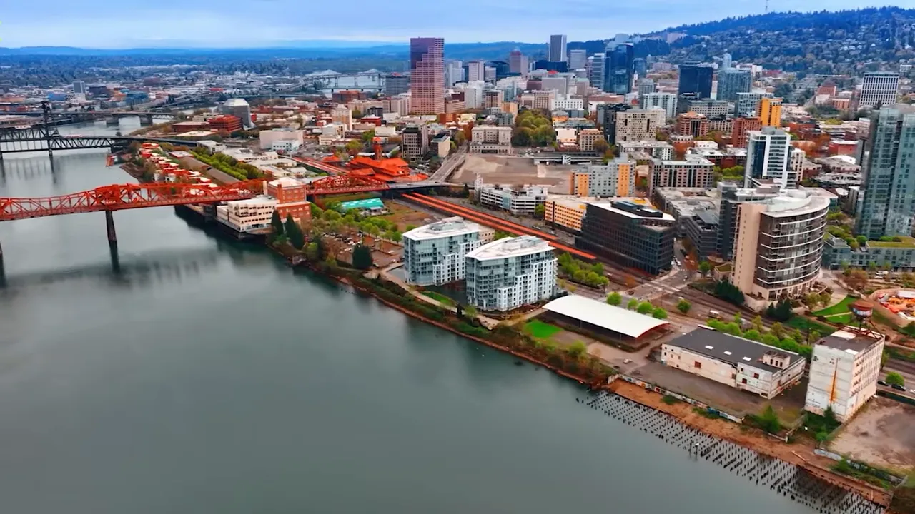 Aerial view of a city skyline and waterfront with bridges and high‑rise buildings, illustrating Northern Oregon urban character.