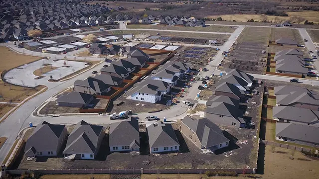 Aerial view of new homes and active construction in a developing neighborhood