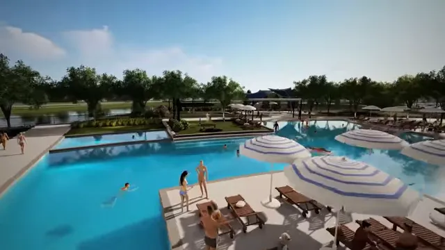 Large resort style swimming pool with lounge chairs and umbrellas
