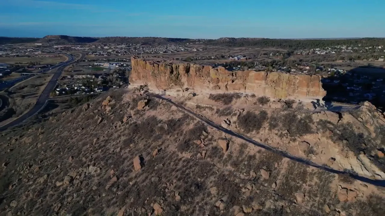 Wide aerial view of Castle Rock’s cliffs and skyline with surrounding neighborhood