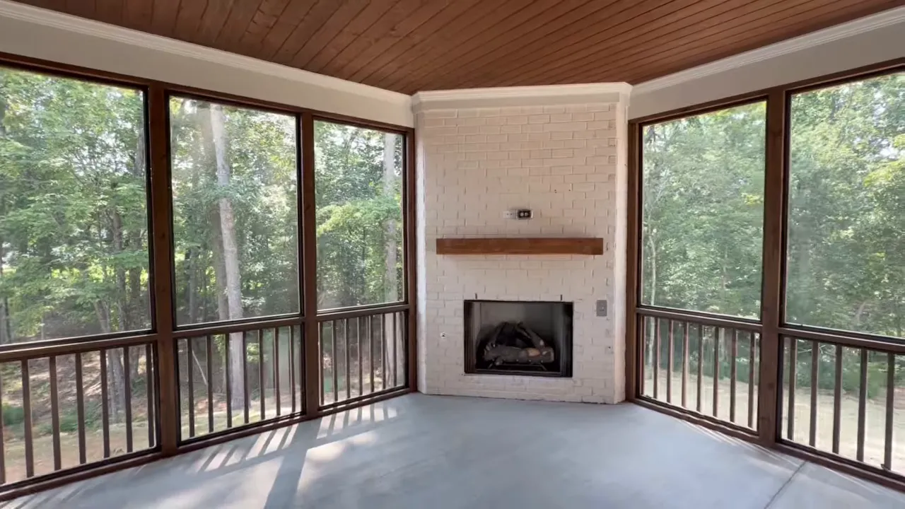 Screened porch with corner fireplace and wooded views
