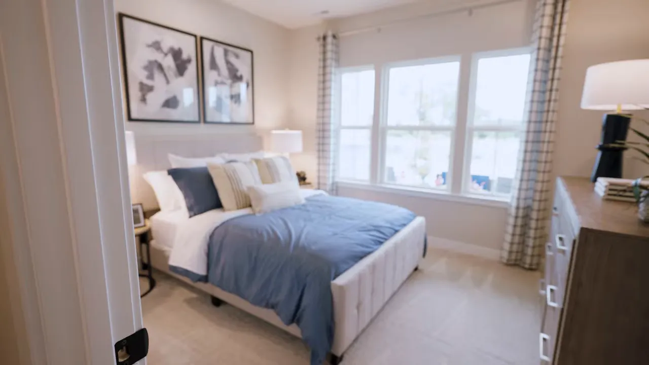 front bedroom with blue bedding low windows and nightstand