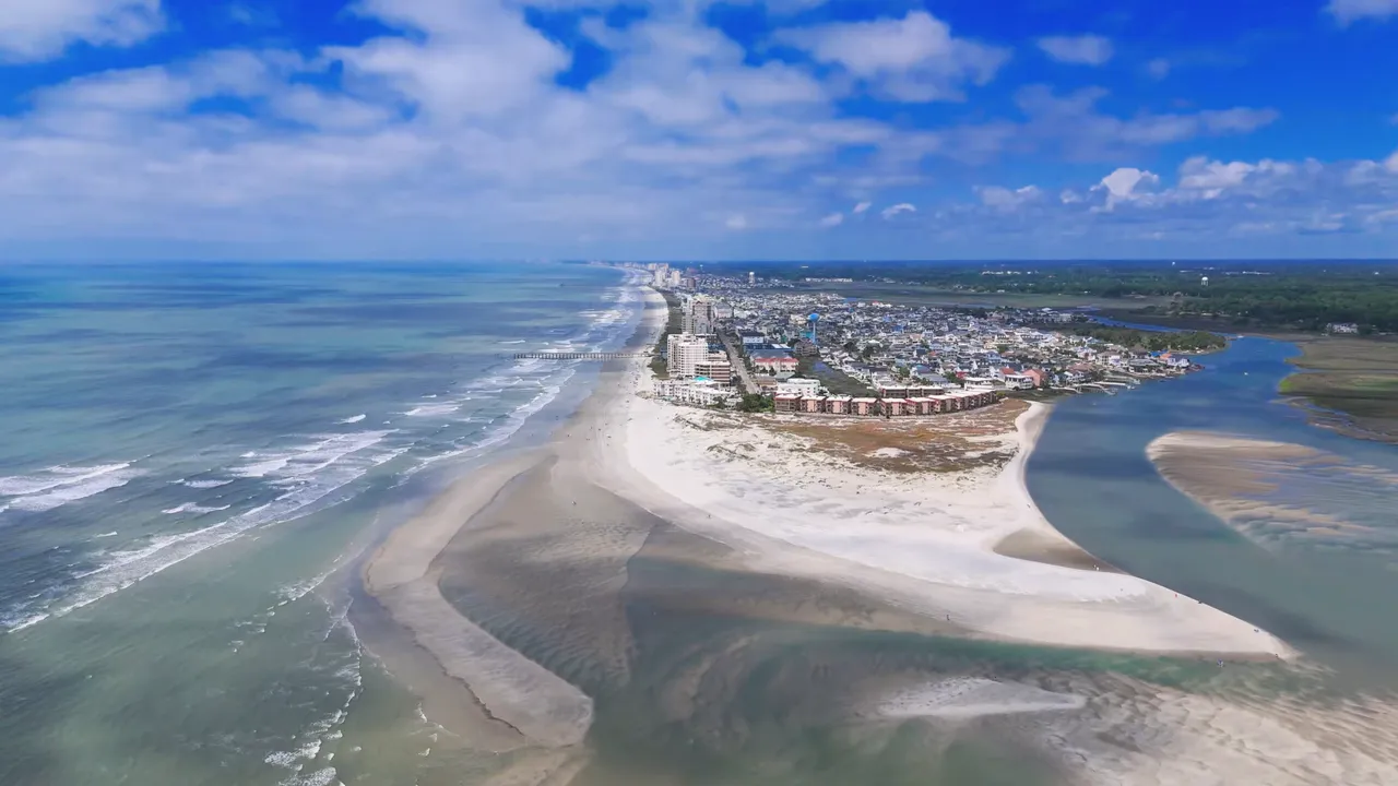 aerial beach view with shoreline ocean and nearby development