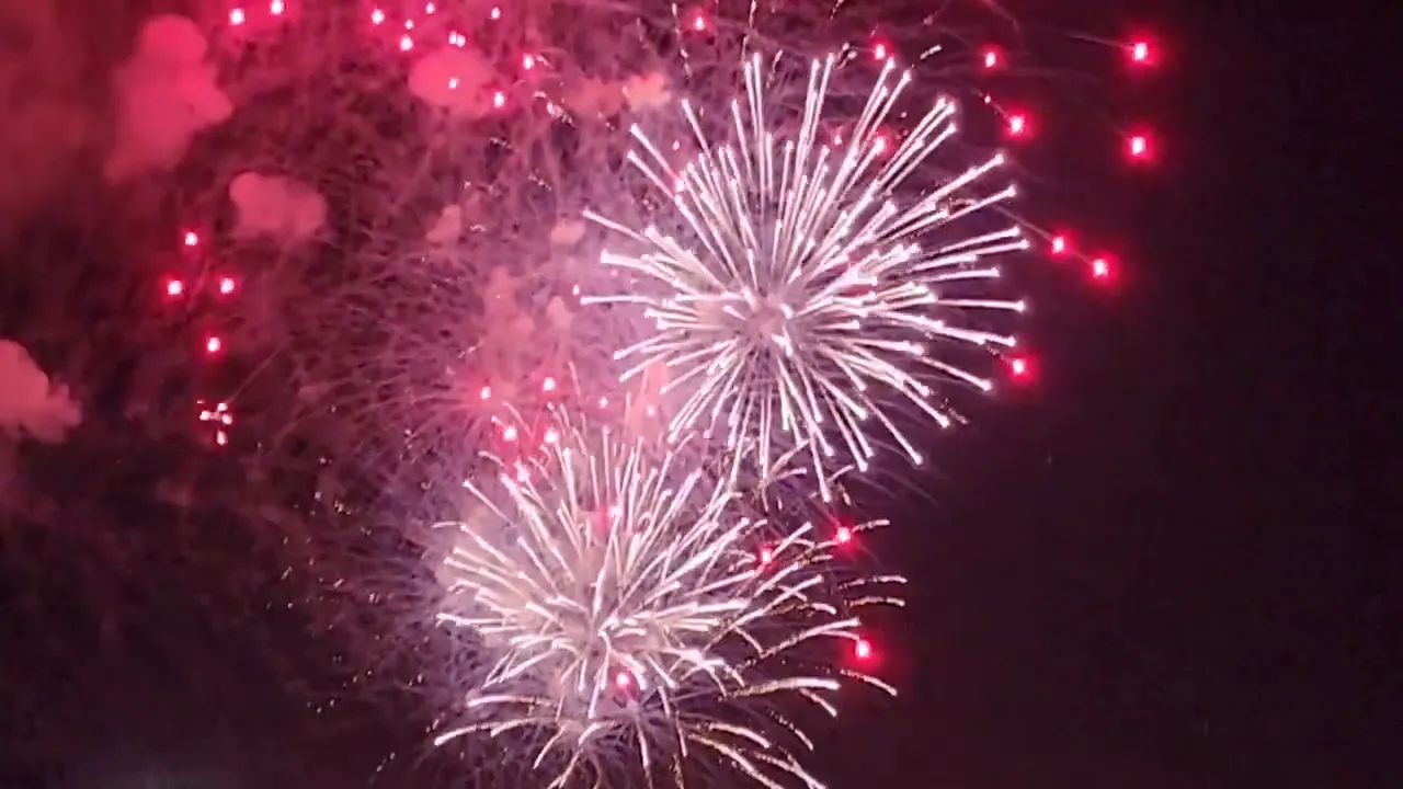 New Albany fireworks display with red lights and white firework bursts