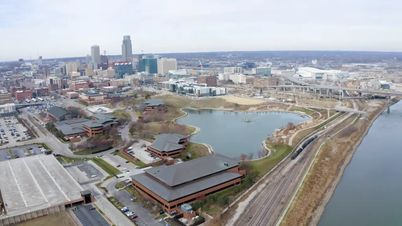 Aerial view of downtown Omaha with riverfront park, trails, and skyline