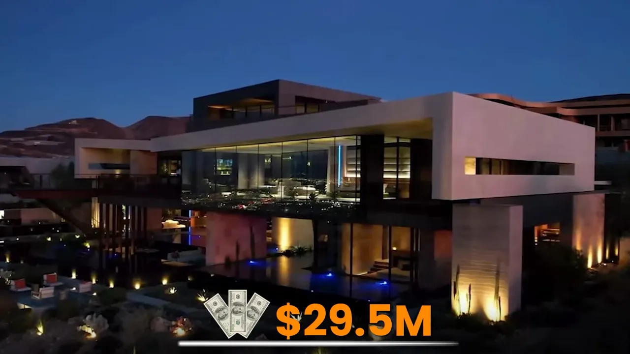 Modern luxury home at night with illuminated pool and desert landscaping