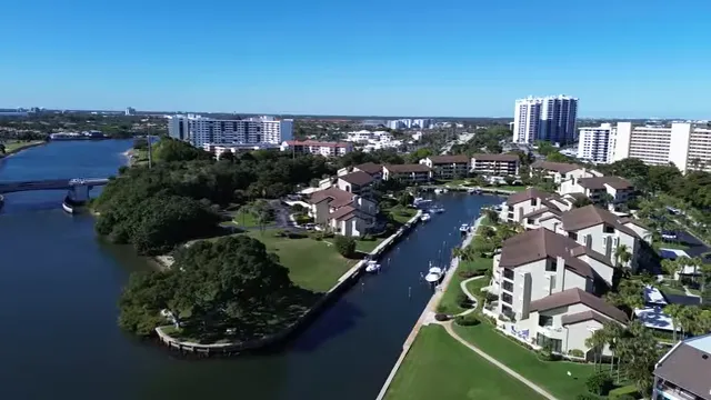 Aerial view of homes lining a canal with boats docked behind them