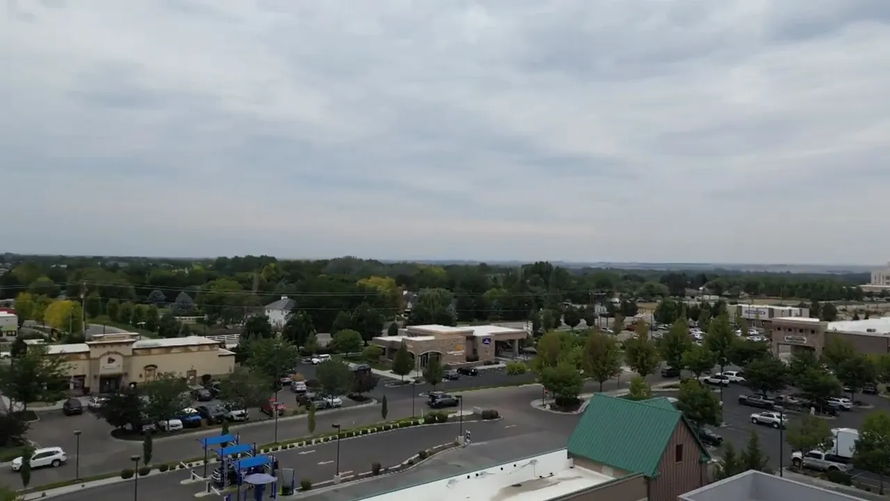Aerial view of low commercial buildings and roads under cloudy skies