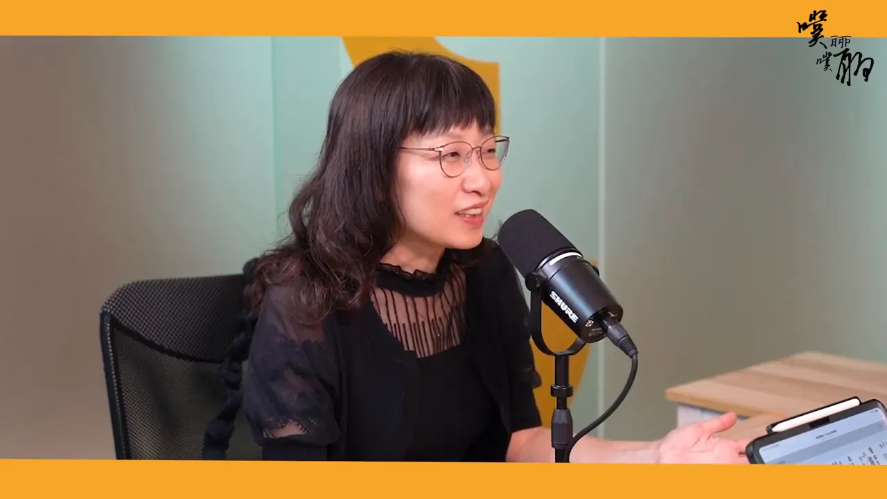 來賓在麥克風前用手勢示範,桌上有平板顯示平台頁面