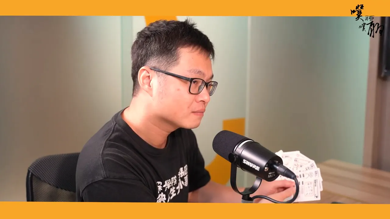 講者在麥克風前展示多張帶有圖示的圖解筆記卡牌,卡片內容可見