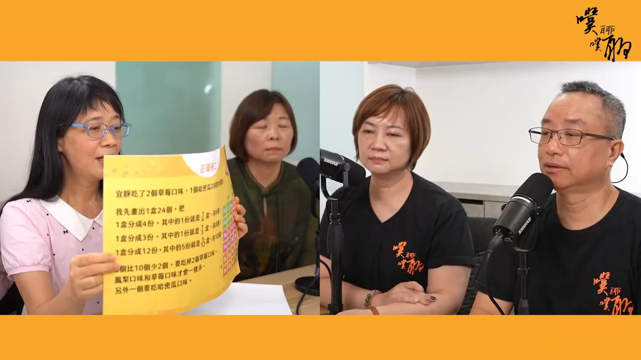 清晰可見的黃色題卡正被主持人展示，題卡上有分數問題與方格，三位與談者與麥克風在畫面右側。