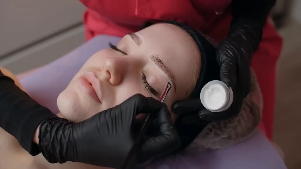 marcação detalhada da sobrancelha em paciente com profissional usando luvas e ferramenta