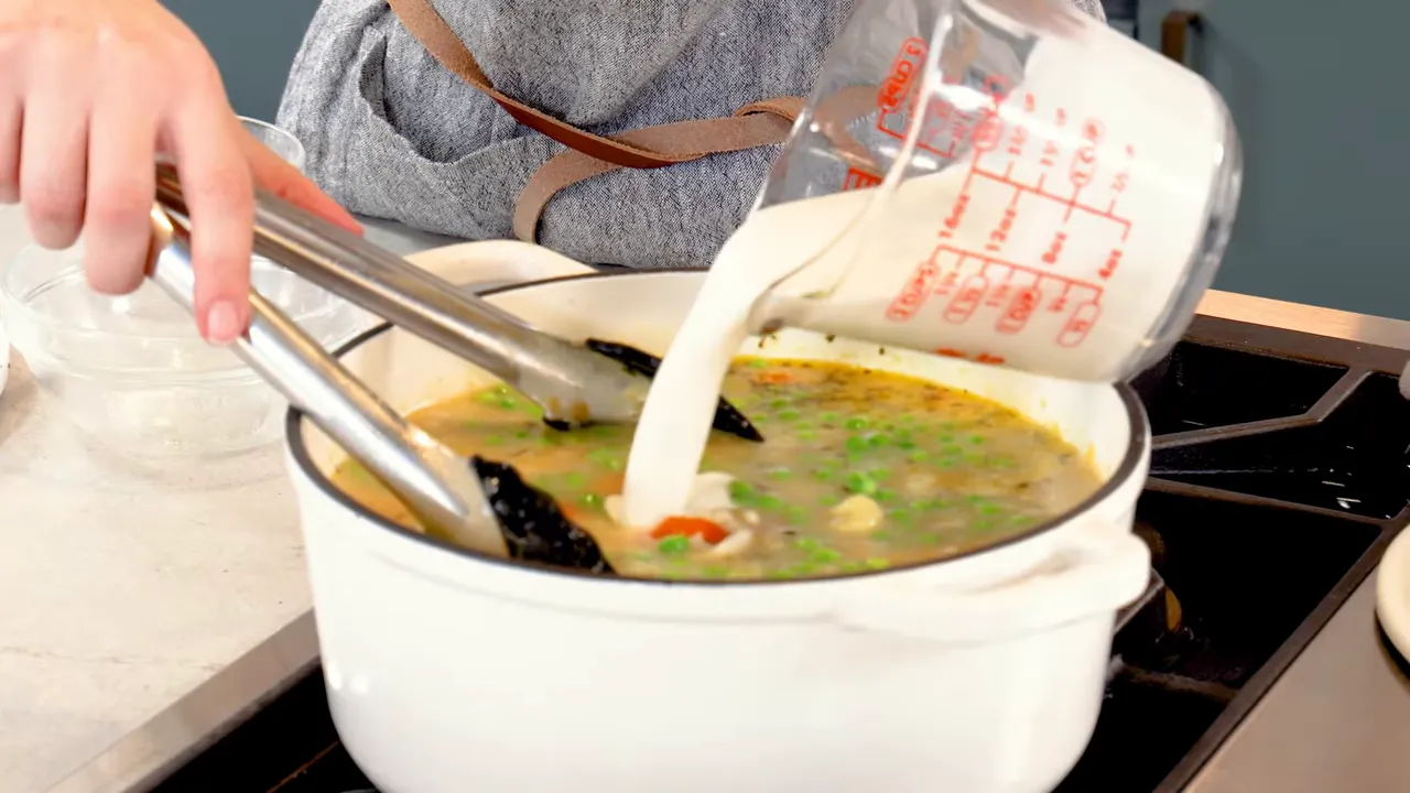 Adding gnocchi and cream to the simmering soup