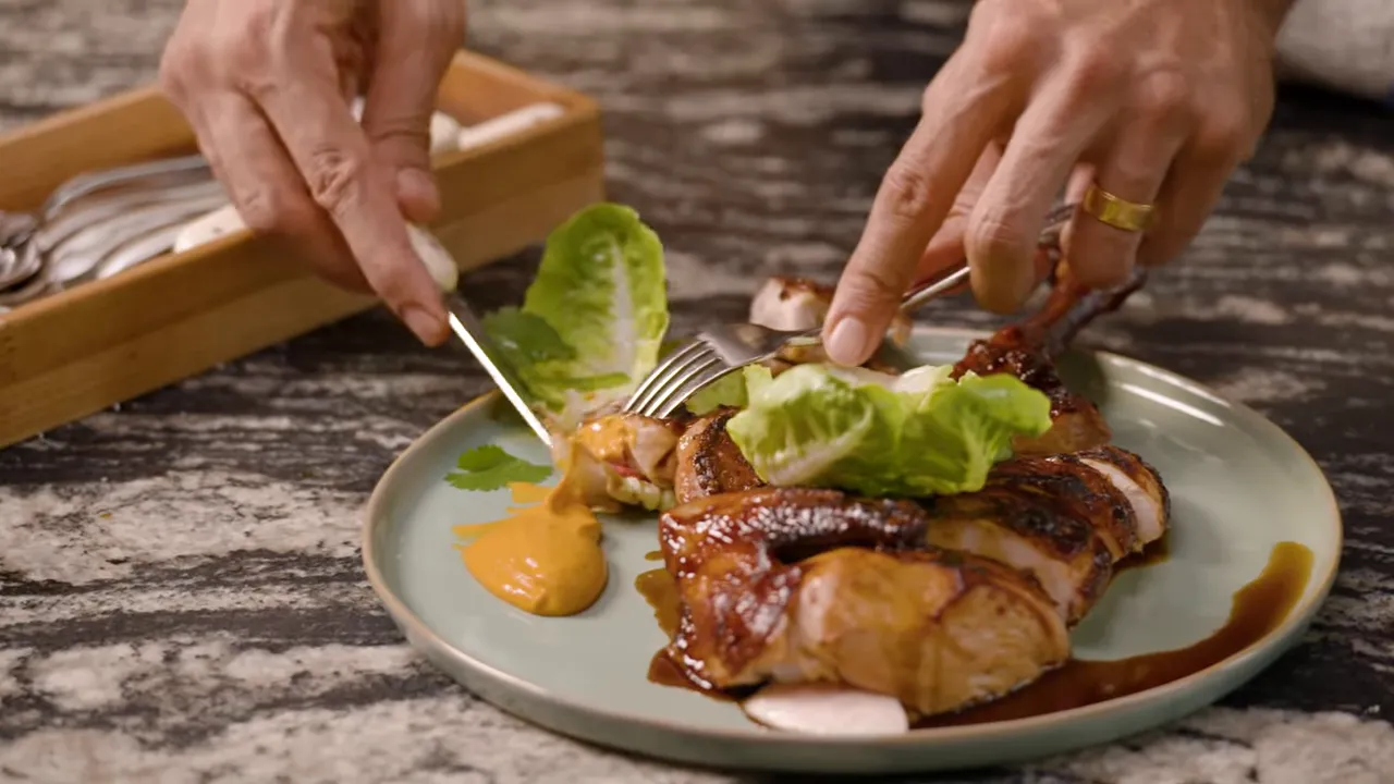 Close-up of crispy roasted chicken skin being pulled apart