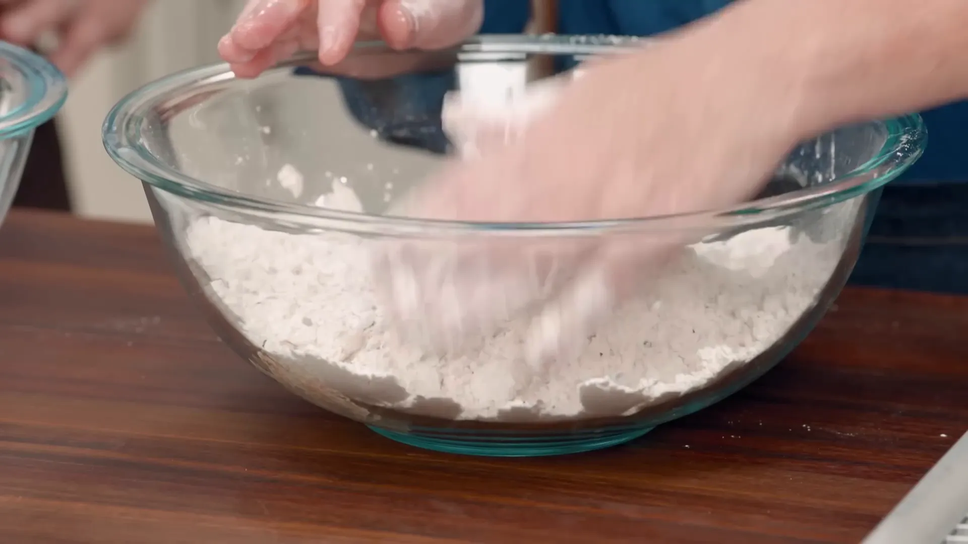 Dredging a chicken thigh in seasoned flour with buttermilk