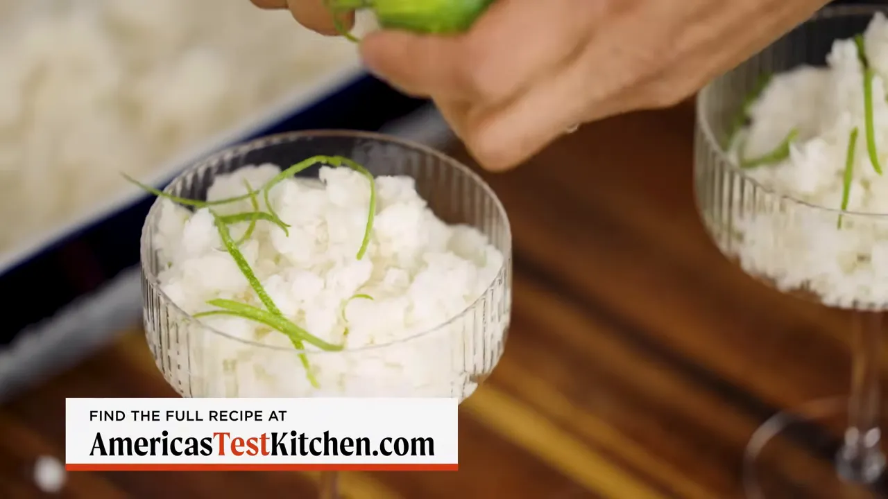 coconut granita in coupe glasses being finished with fresh lime zest