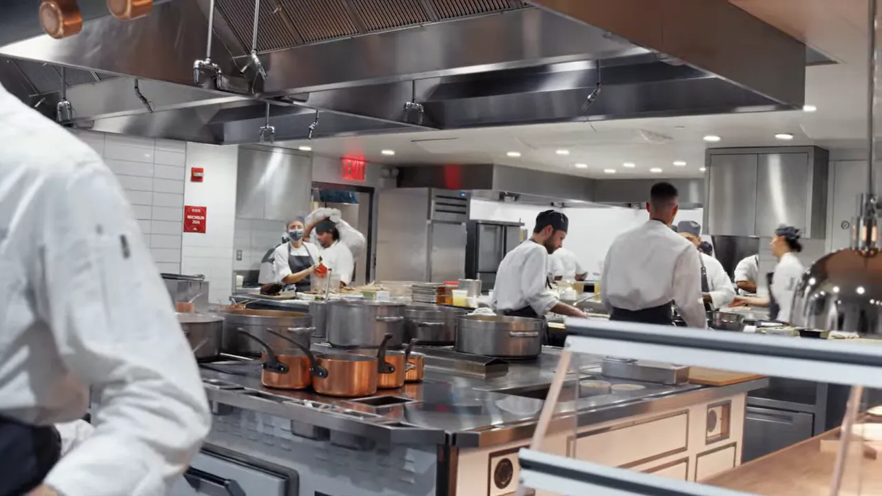 Busy hot line with multiple cooks and copper pans in a professional kitchen