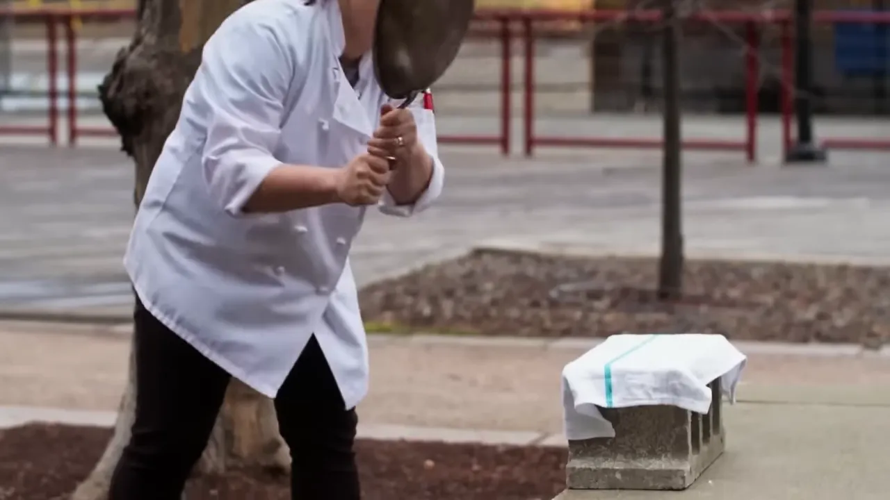 A tester whacking a skillet to check structural strength