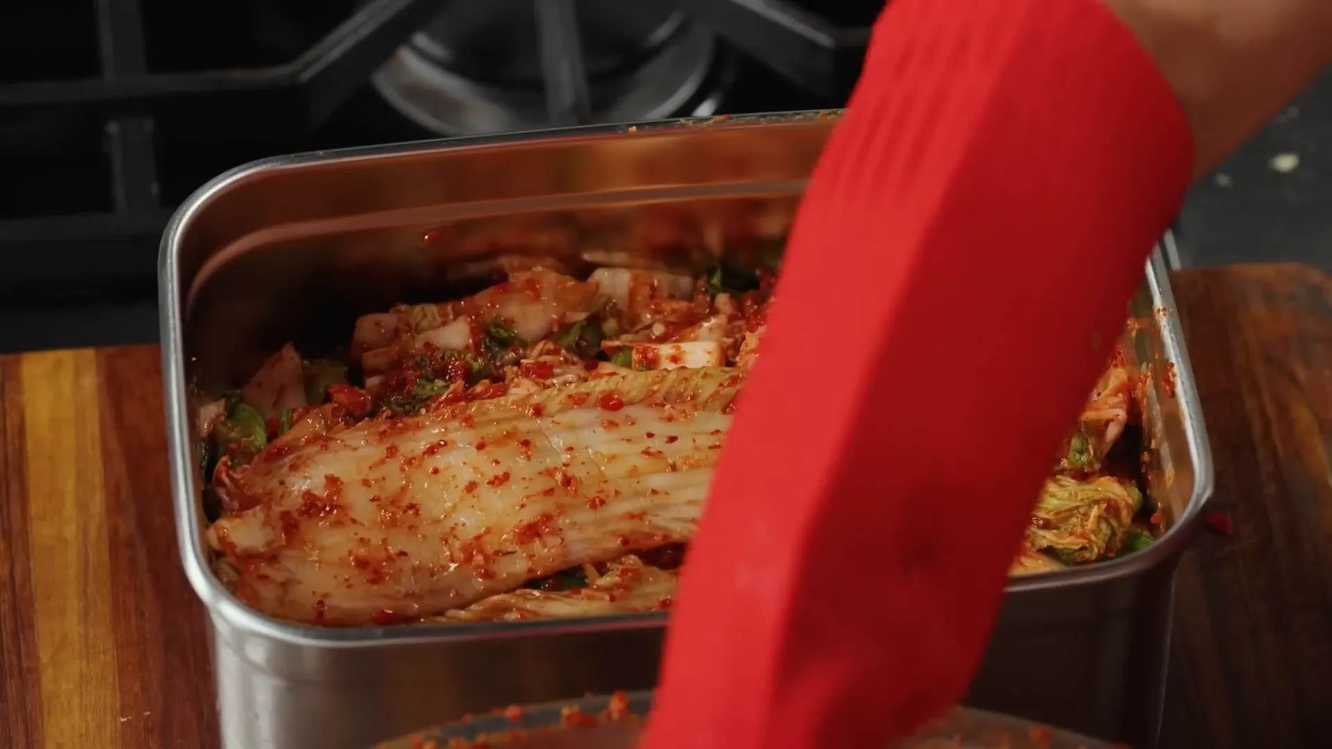 Packing kimchi into container and covering with outer cabbage leaves