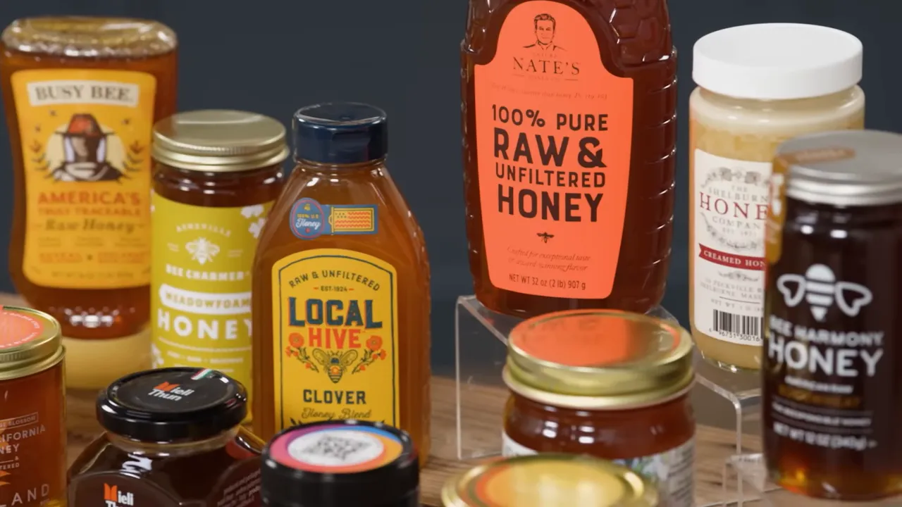 Assortment of grocery-store honey jars, including a bottle labeled 100% raw & unfiltered honey